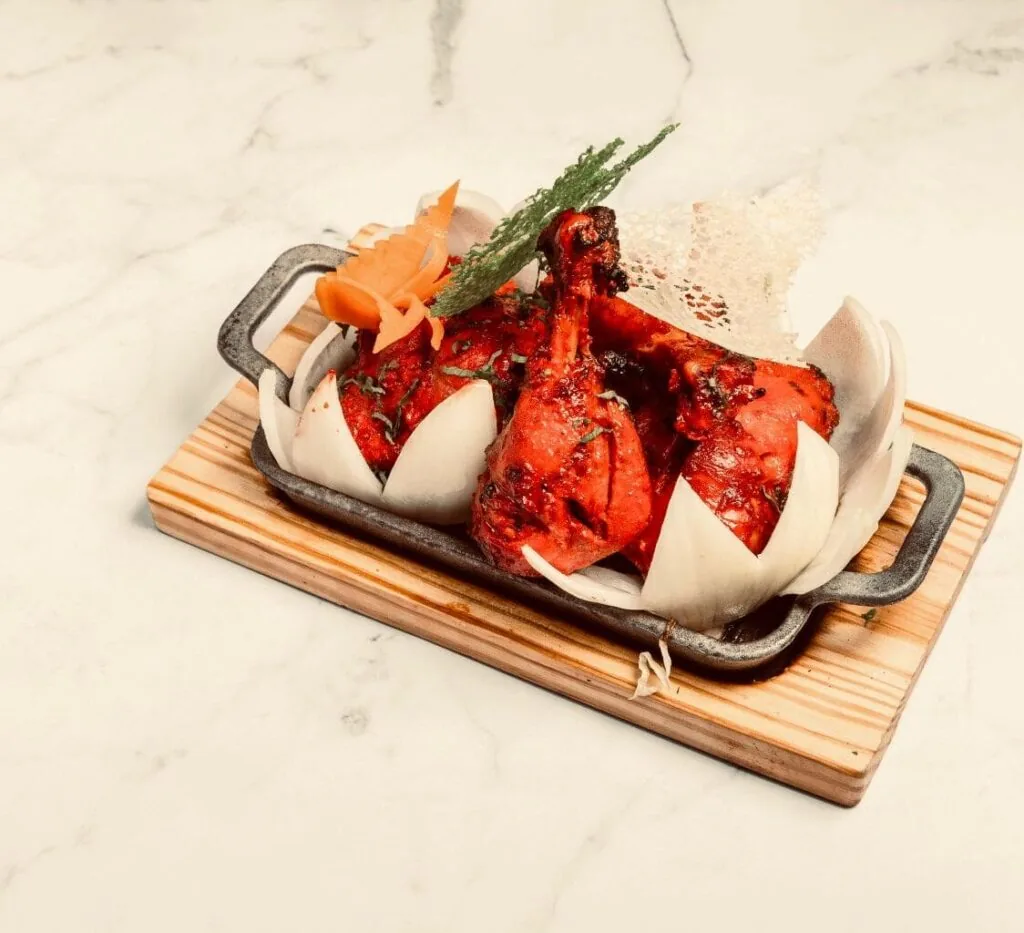 Pollo tandoori con cebolla servido en Himalaya Arturo Soria